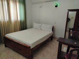a small bedroom with a bed and a table at GD Guest in Bentota