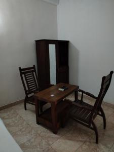 a wooden table and two chairs in a room at GD Guest in Bentota