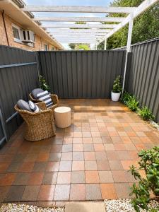a patio with a pergola and chairs on a fence at Coastal Studio in Seacliff