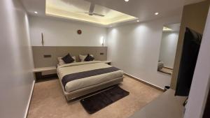 a bedroom with a large bed and a mirror at Hotel Anukampa in Rāmgarh +4 photos