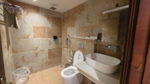 a bathroom with a toilet and a sink at Hotel Anukampa in Rāmgarh