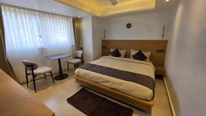 a bedroom with a bed and a table and chairs at Hotel Anukampa in Rāmgarh