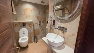 a bathroom with a toilet and a sink and a mirror at Hotel Anukampa in Rāmgarh