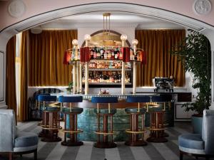 a bar at a hotel with blue bar stools at The Georgian, in The Unbound Collection by Hyatt in Santa Monica