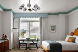 a bedroom with a bed and a table and a window at The Georgian, in The Unbound Collection by Hyatt in Santa Monica +111 photos