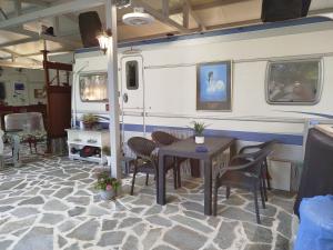 a dining room with a table and chairs and an rv at DamAnda mare in Nea Potidaea
