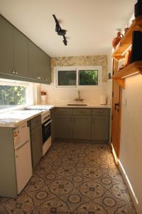 a kitchen with green cabinets and a sink at A Lómbre in Ḩarīq al Kufūr +14 photos