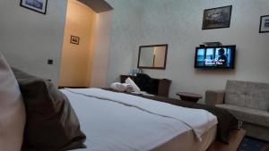 a hotel room with a bed and a flat screen tv at Porto Bistro in Baku