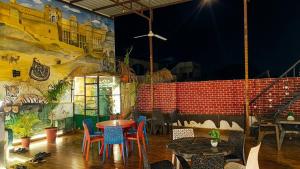 a restaurant with a table and chairs and a mural at Rajputana cafe and restaurant in Dausa
