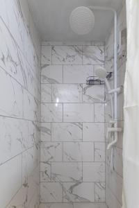 a bathroom with white marble walls and a shower at Fiesta in Solotvyno +36 photos