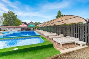 a swimming pool with chaise lounge chairs next to a fence at Fiesta in Solotvyno