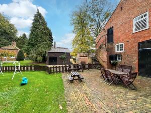 a backyard with a table and benches and a brick building at Stables - Uk51018 in Louth