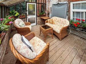 a patio with wicker furniture and a table and chairs at Stables - Uk51018 in Louth