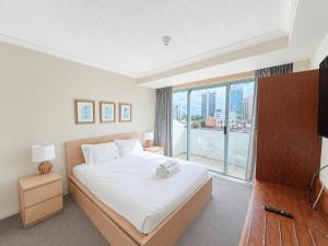 a bedroom with a bed and a large window at Serain Residences on Legends in Gold Coast +26 photos