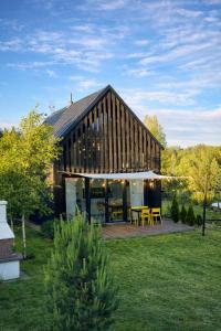 a large barn with a table and chairs in a yard at Siedlisko Ciemno in Ciemno
