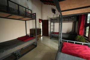 a room with three bunk beds in a building at Secret Ashram Coorg in Kushālnagar