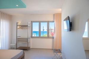 a room with a bed and a window with the ocean at Lumina Rooms in Torre dell'Orso