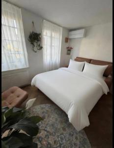 ein großes weißes Bett in einem Zimmer mit Fenstern in der Unterkunft Emma in Thun