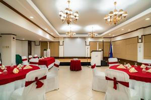 a banquet hall with red and white tables and chairs at Crown Regency Residences Davao in Davao City +88 photos