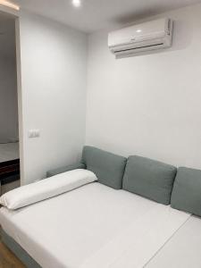 a white couch in a white room with a air conditioner at apartamento en centro in Chipiona