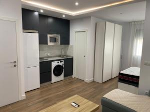 a kitchen with white cabinets and a washer and dryer at apartamento en centro in Chipiona
