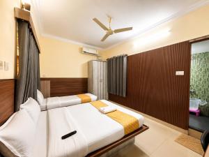 a bedroom with a bed and a ceiling fan at HOTEL Nh MAJESTIC in Bangalore +16 photos