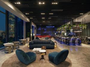 a lobby with blue couches and chairs and tables at SO/ Bangkok in Bangkok