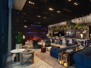 a lobby with couches and tables and a bar at SO/ Bangkok in Bangkok