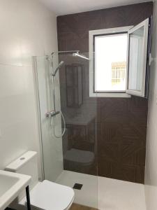 a bathroom with a shower with a toilet and a window at apartamento en centro in Chipiona