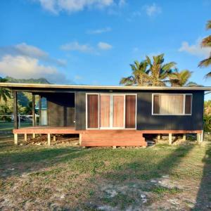 a modern house with a black facade at Kuki Beach Bach in Rarotonga