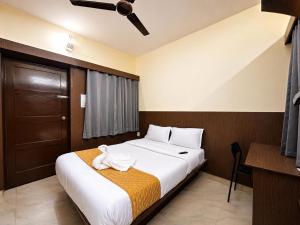 a hotel room with a bed and a ceiling fan at HOTEL Nh MAJESTIC in Bangalore