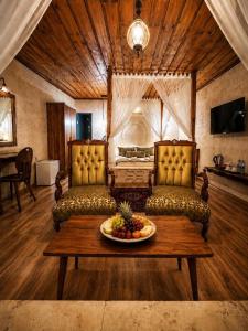 a living room with two couches and a bowl of fruit on a table at Sakli Cave House in Avanos