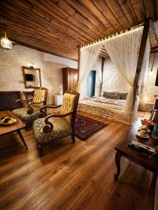 a living room with a bed and a table and chairs at Sakli Cave House in Avanos +110 photos