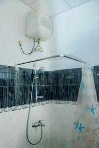 a shower with a shower head in a bathroom at Caritas Rest in Galle