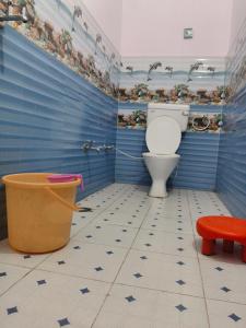 a bathroom with a toilet and a blue wall at R K Hotel & HELY ROOMS in Phata
