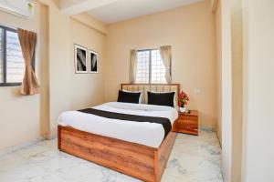 a bedroom with a large bed and a window at Super Hotel O Dehu Pune Formerly Gathaa Inn in Dehu