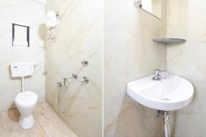 a white bathroom with a toilet and a sink at Super Hotel O Dehu Pune Formerly Gathaa Inn in Dehu