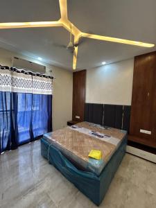 a bedroom with a bed in a room with blue curtains at Balaji villa in Juliāsar