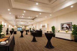 a hotel lobby with tables and chairs and a bar at Hilton Pasadena in Pasadena