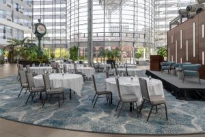 a restaurant with white tables and chairs and a clock at DoubleTree by Hilton Hotel South Bend in South Bend