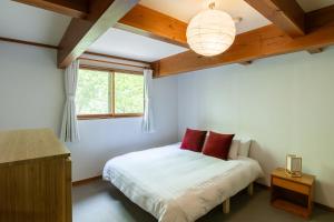 a bedroom with a bed and a window at Ikiru Lodge in Yamanouchi