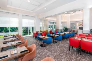 a restaurant with tables and chairs and windows at Hilton Garden Inn Wayne in Wayne