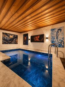 a swimming pool in a room with paintings on the wall at Sakli Cave House in Avanos