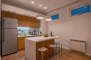 a kitchen with a refrigerator and a counter with stools at Hyacinth House in Tbilisi City