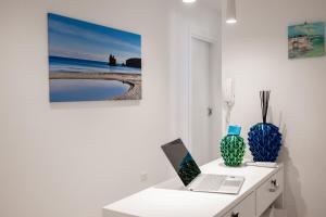 a desk with a laptop and vases on it at Lumina Rooms in Torre dell'Orso