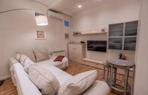 a living room with a couch and a tv at Hyacinth House in Tbilisi City