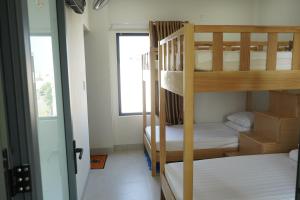 two bunk beds in a small room with a window at Morgan Hotel in Ấp Bình Hưng