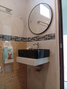 a bathroom with a black and white sink and a mirror at Stylish 1BR Retreat with Workspace & Hammock in Hinkong