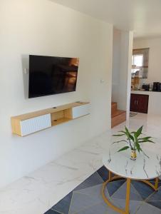 a living room with a tv on a wall at Stylish 1BR Retreat with Workspace & Hammock in Hinkong