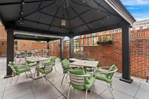 a patio with tables and chairs and a brick wall at Comfort Suites Bethlehem Near Lehigh University and LVI Airport in Bethlehem